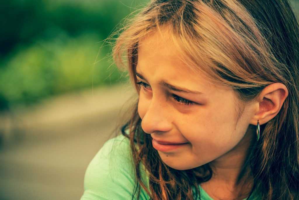 Closeup portrait of young crying girl with tears